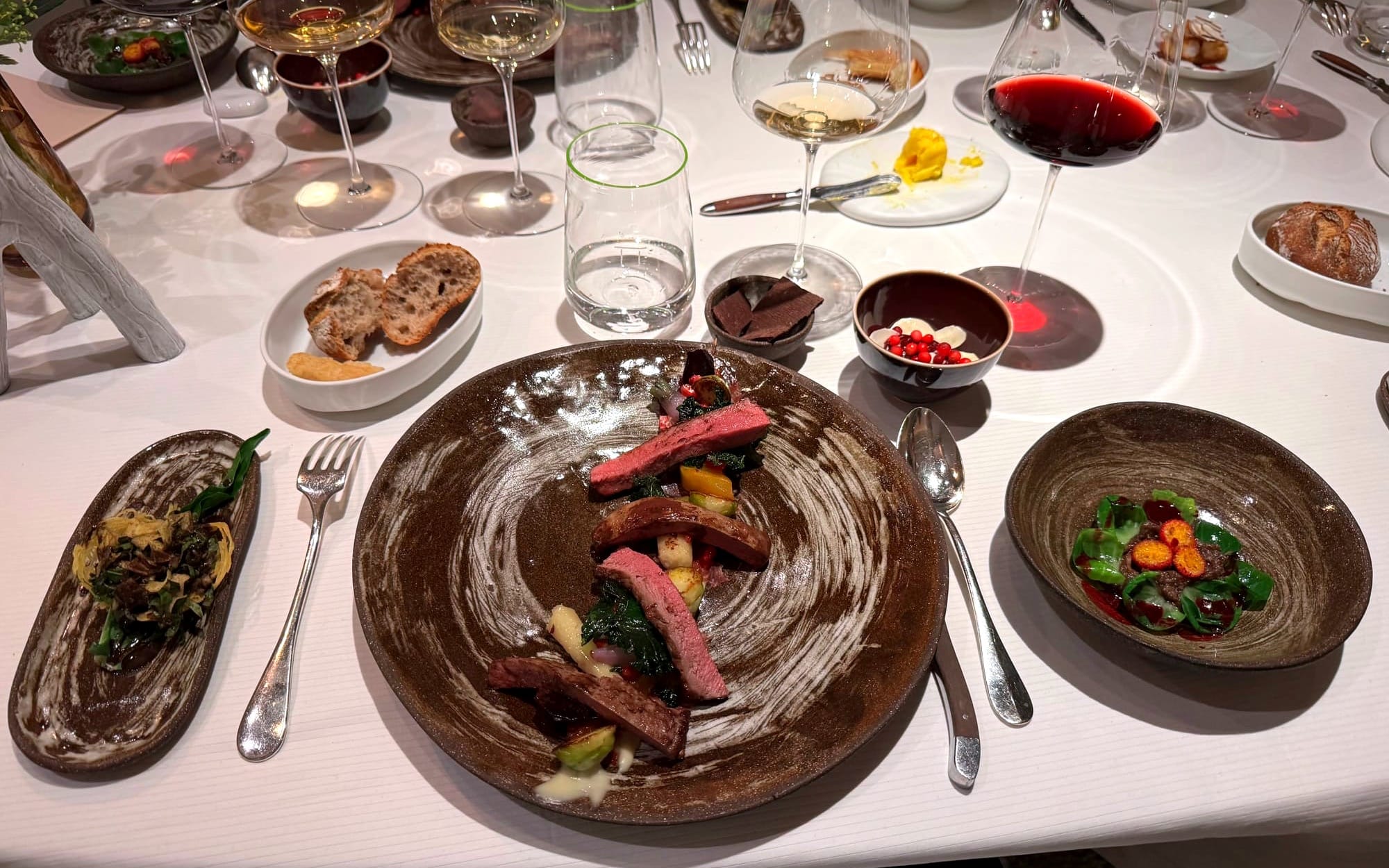 enison with autumn vegetables and a concentrated game jus, presented in Pierre Gagnaire’s signature multi-plate style.