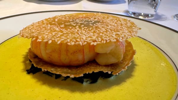 L’Ambroisie’s signature langoustine feuillantine with sesame tuile and aromatic curry sauce.